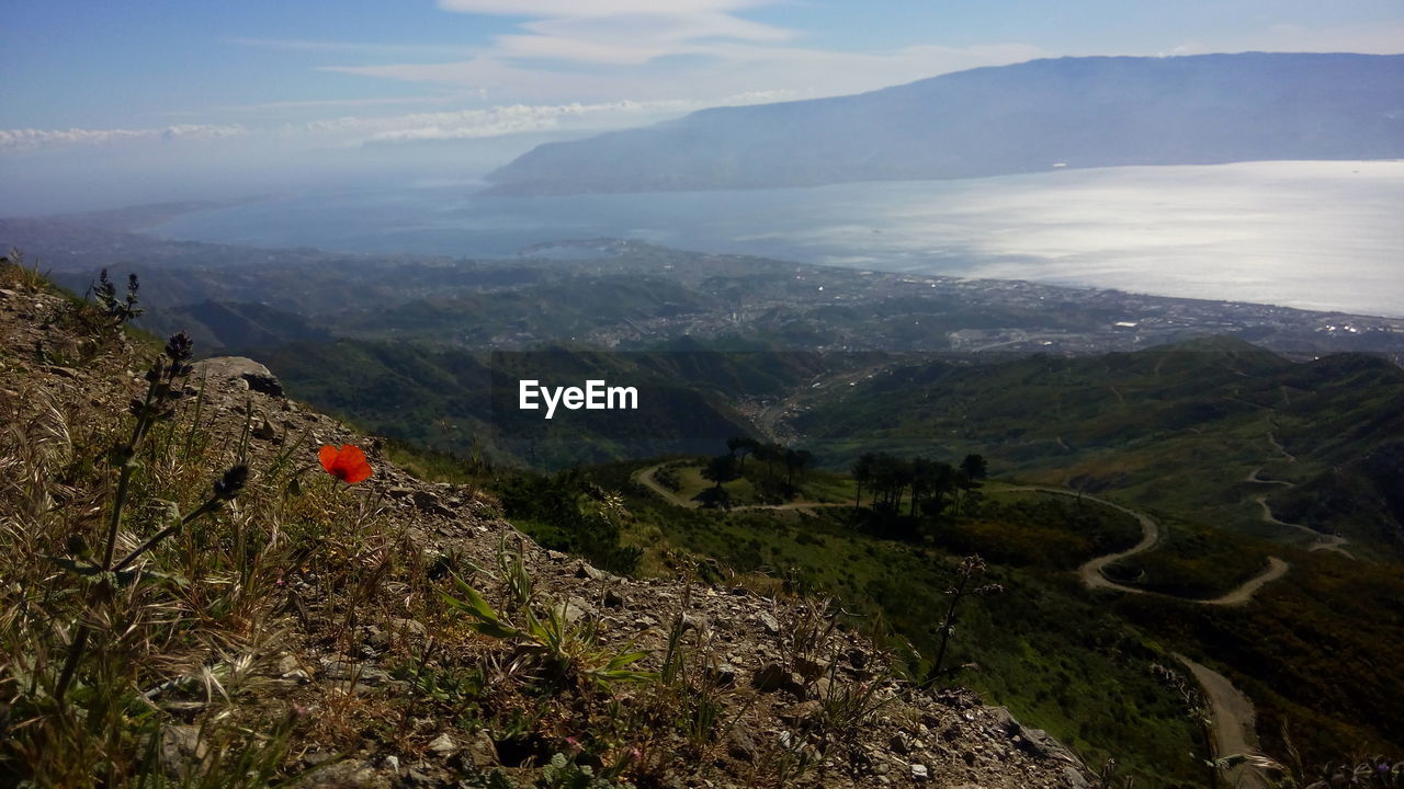 HIGH ANGLE VIEW OF MAN ON MOUNTAIN AGAINST SKY