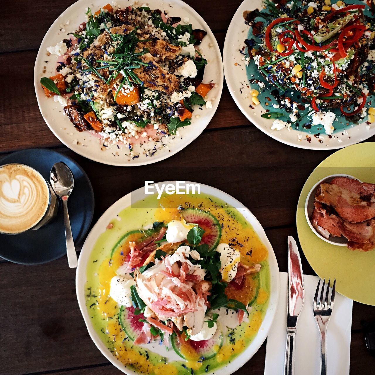 High angle view of food and latte in plates on table