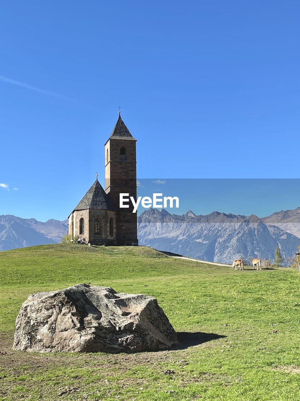 Church on field against blue sky at bozen