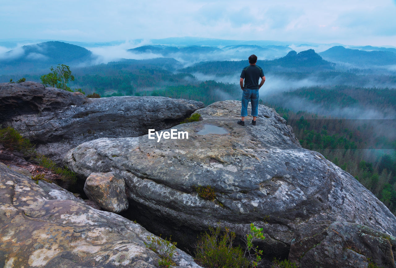 Man enjoy view at foggy morning in saxon switzerland. saxony region, germany