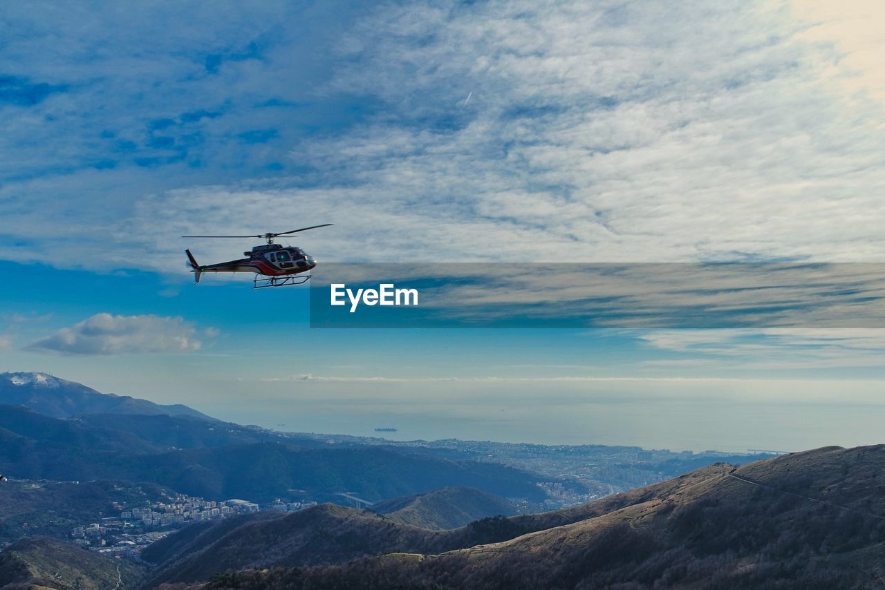 Low angle view of helicopter flying against sky