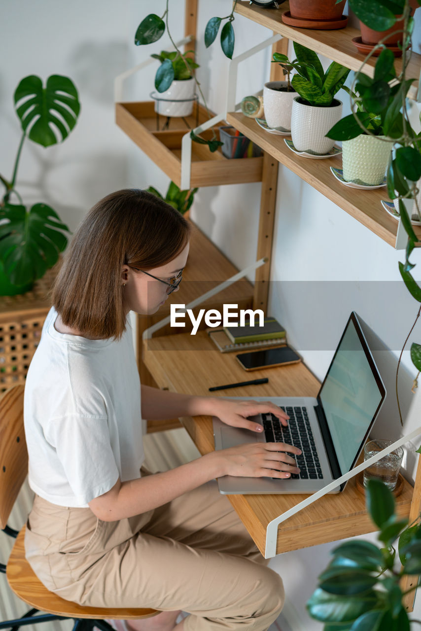 Young woman working on laptop from home.