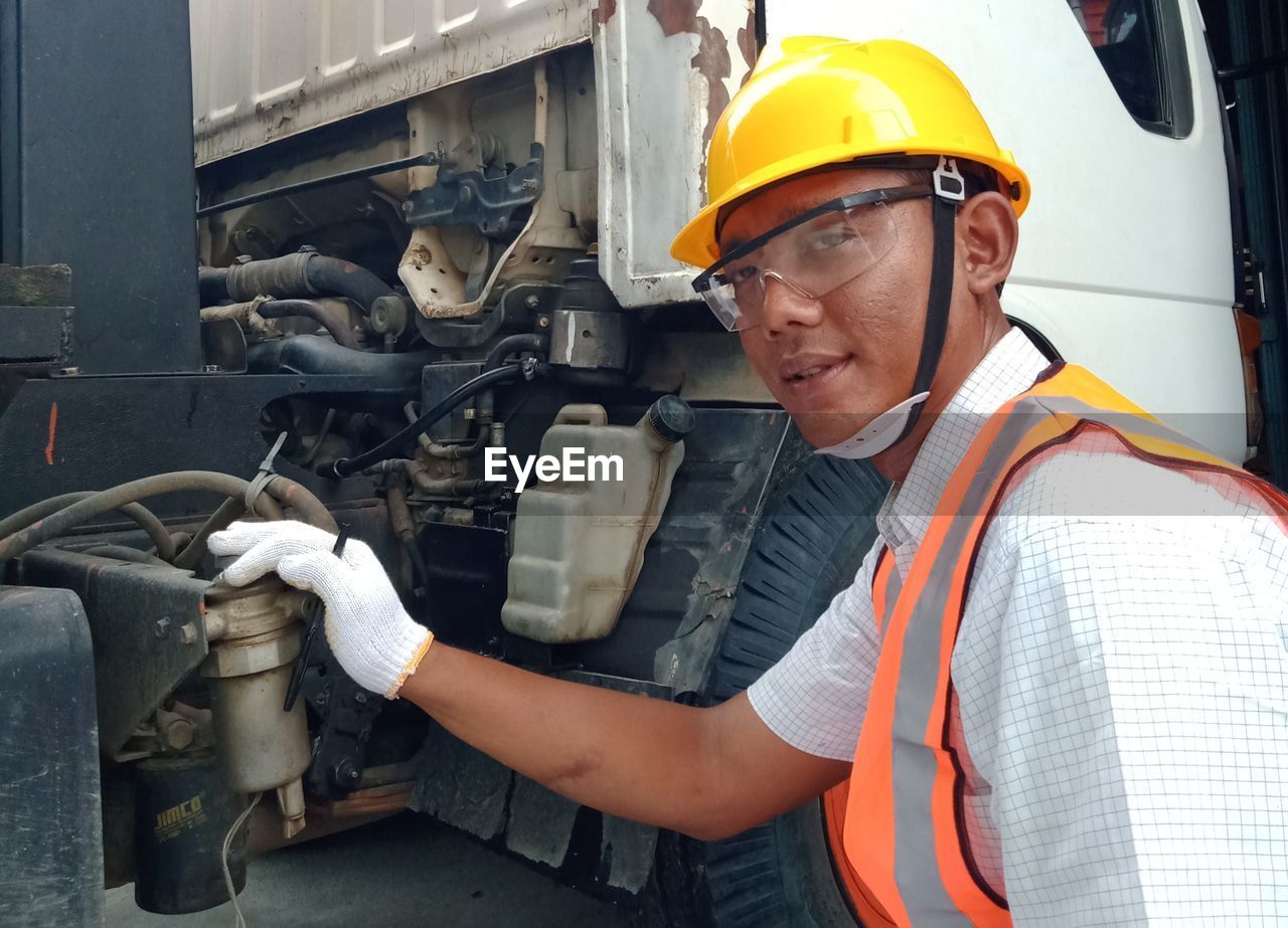 PORTRAIT OF SENIOR MAN WORKING IN OFFICE