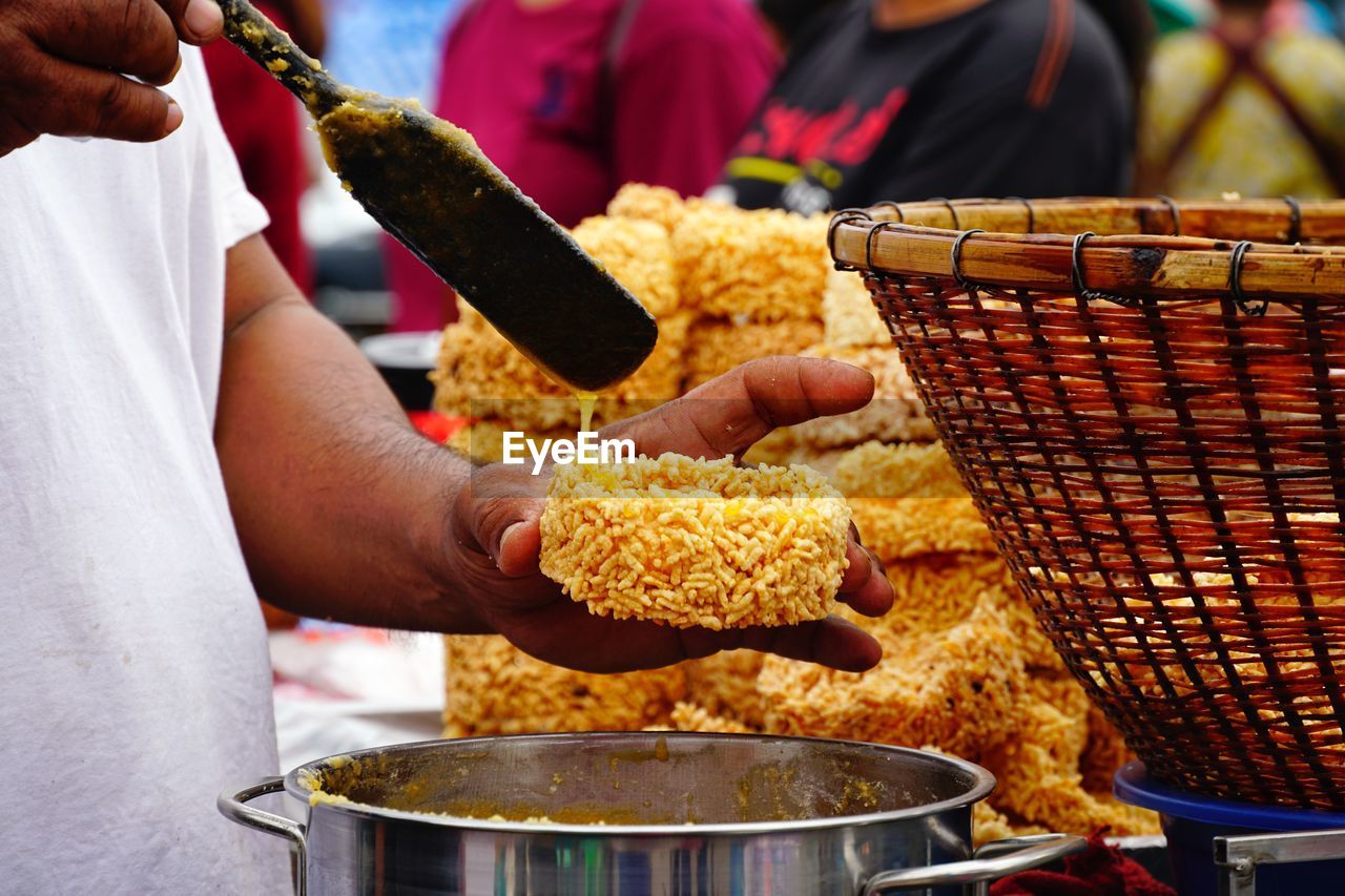 Midsection of man preparing food at market stall