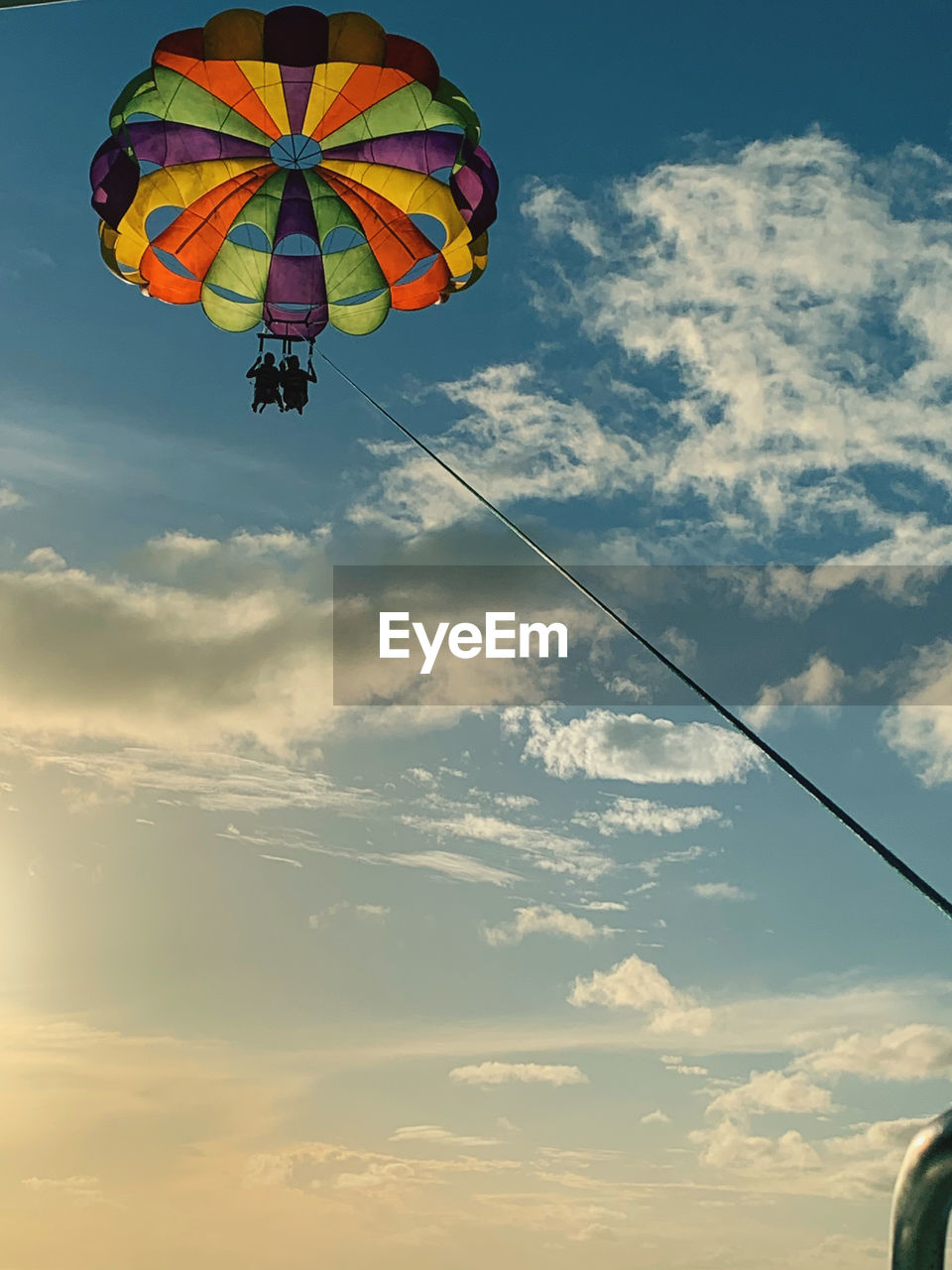 Low angle view of person paragliding against sky