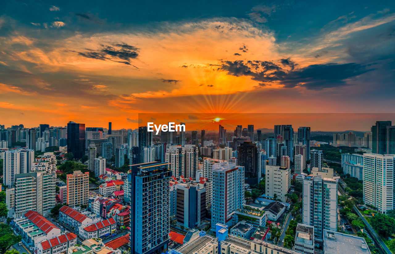 Aerial view of modern buildings against sky during sunset