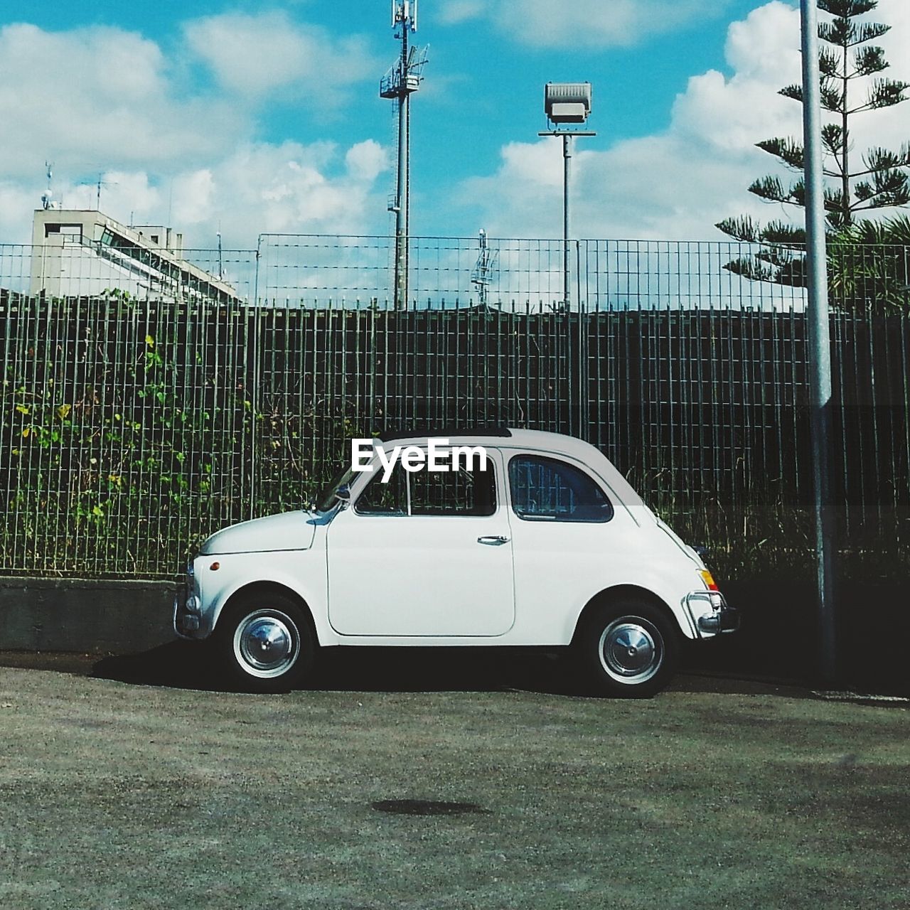 Car parked in front of railing against cloudy sky