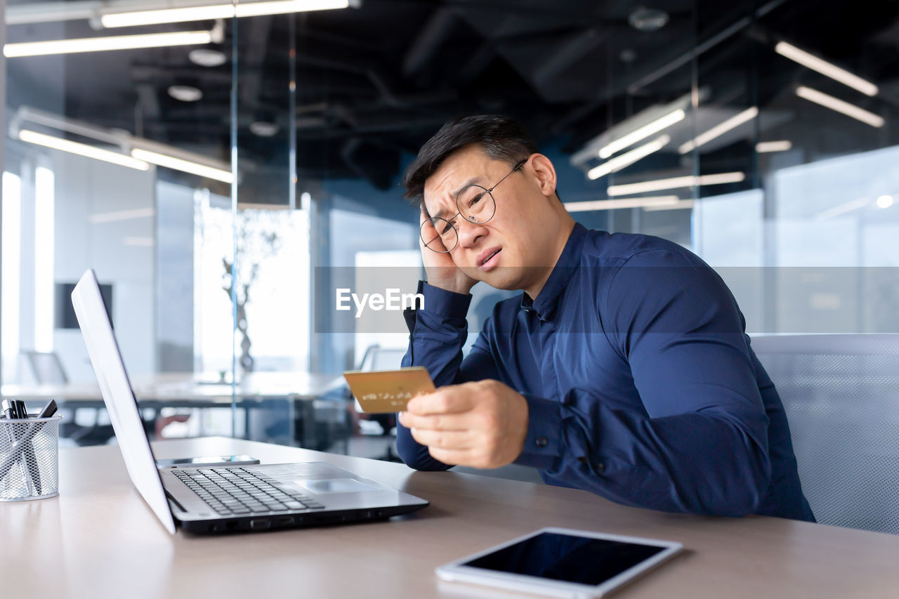 side view of man using digital tablet while standing in office