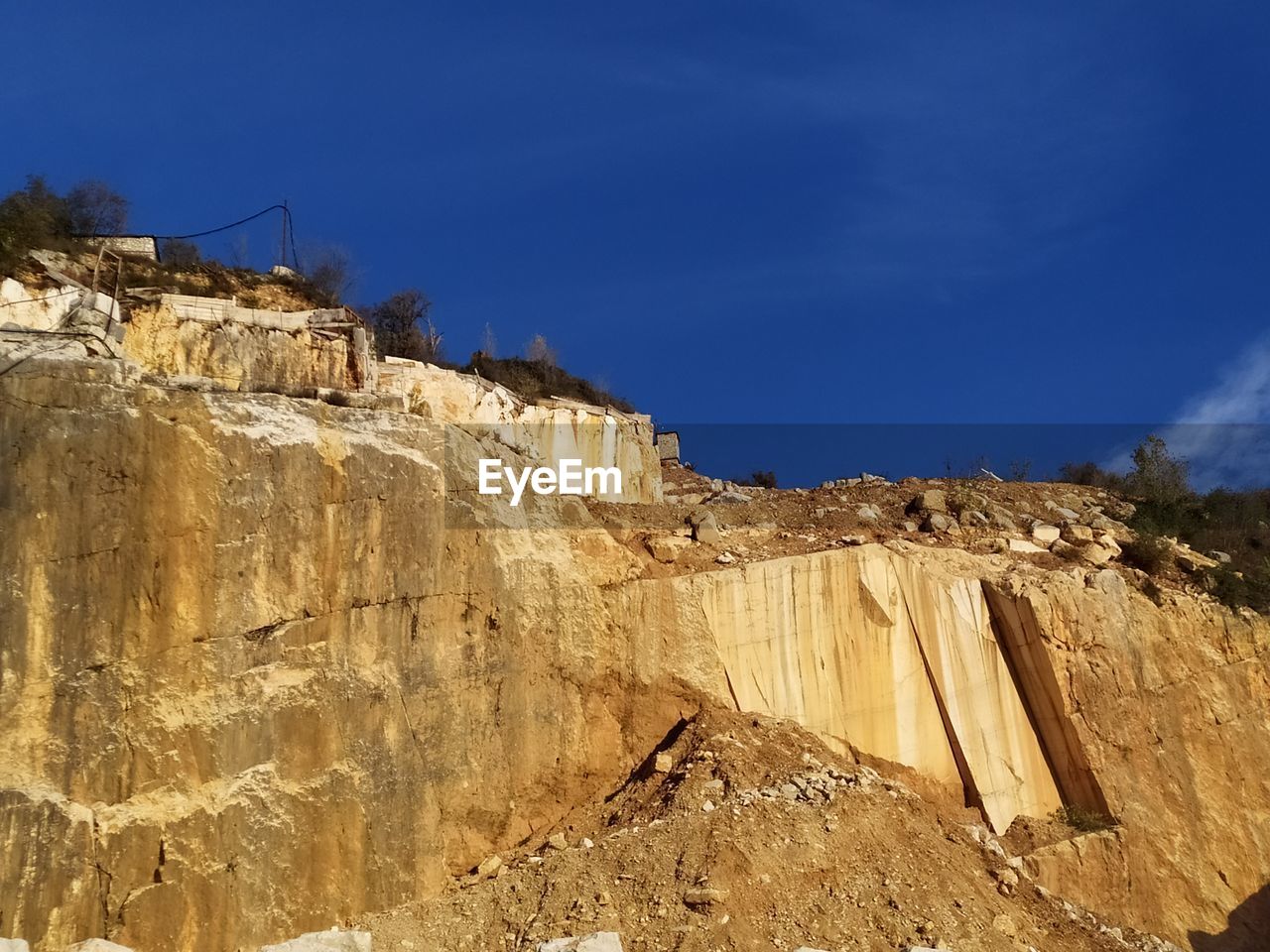 LOW ANGLE VIEW OF ROCK FORMATIONS AGAINST BLUE SKY