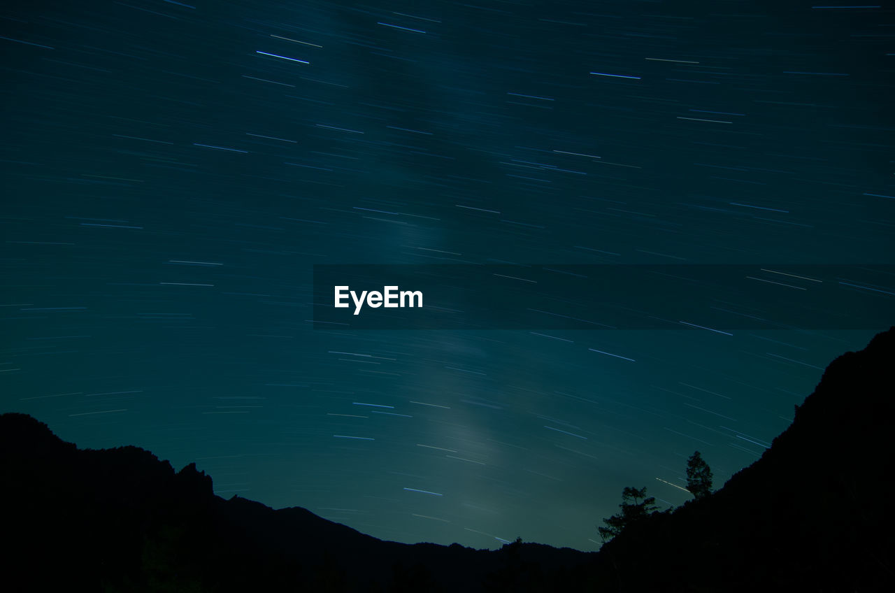 Low angle view of silhouette star field against sky at night