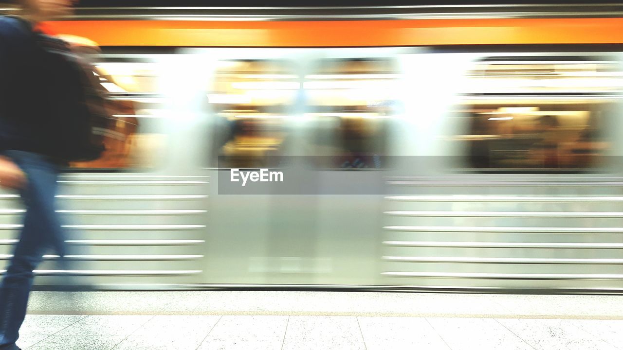 BLURRED MOTION OF WOMAN ON TRAIN AT RAILROAD STATION PLATFORM