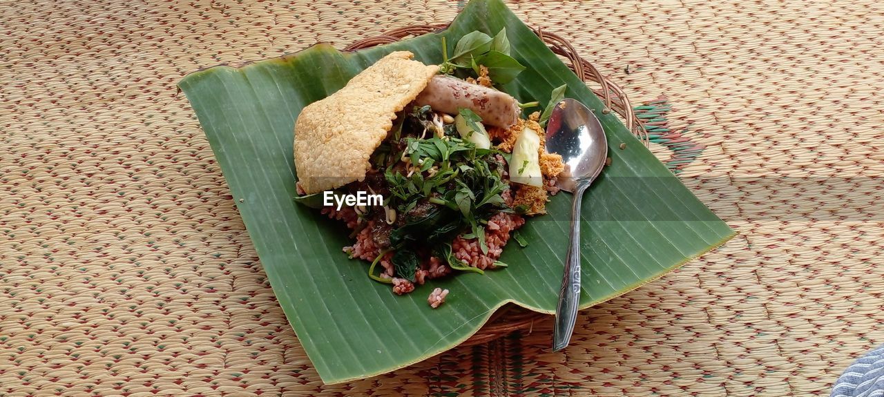Pecel ndeso, indonesian traditional food served on a plate covered with banana leaves