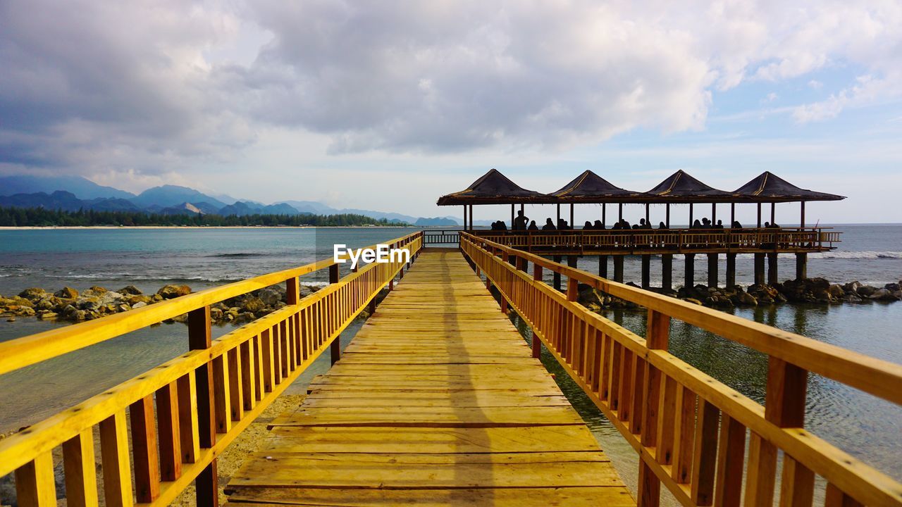 PIER ON BEACH AGAINST SKY