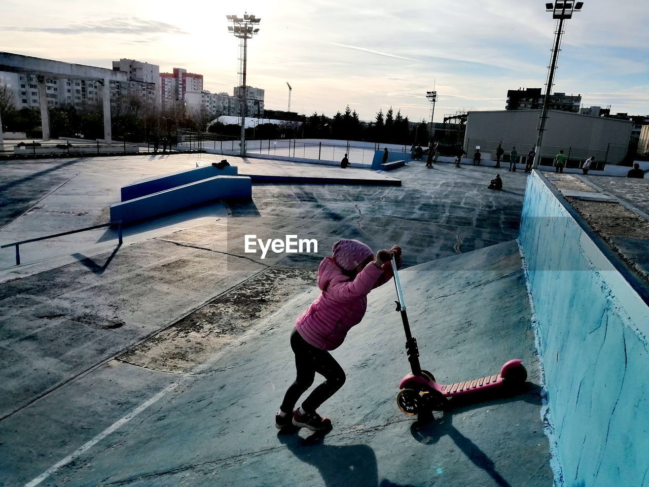 Girl playing with push scooter outdoors