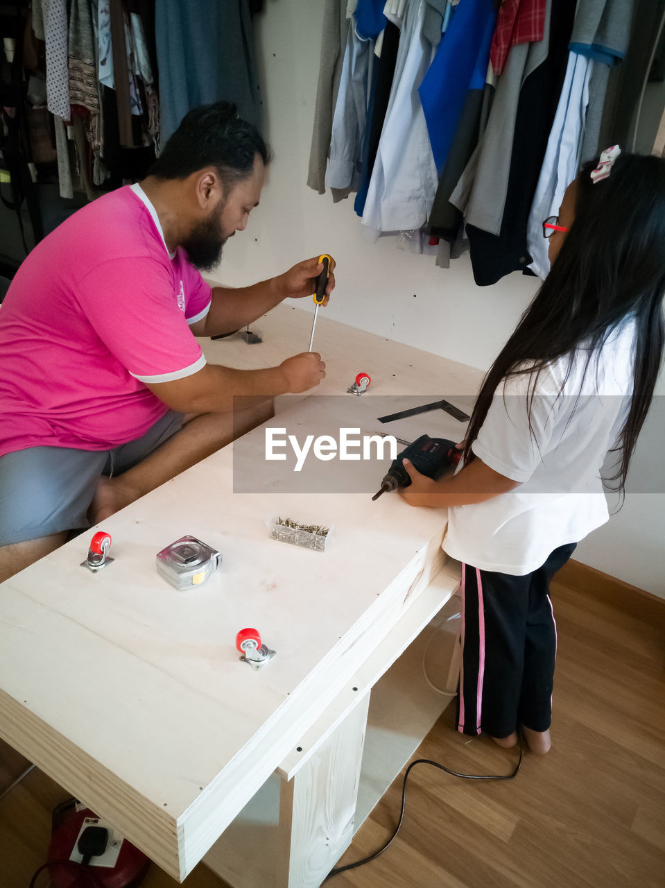 Man with girl repairing table