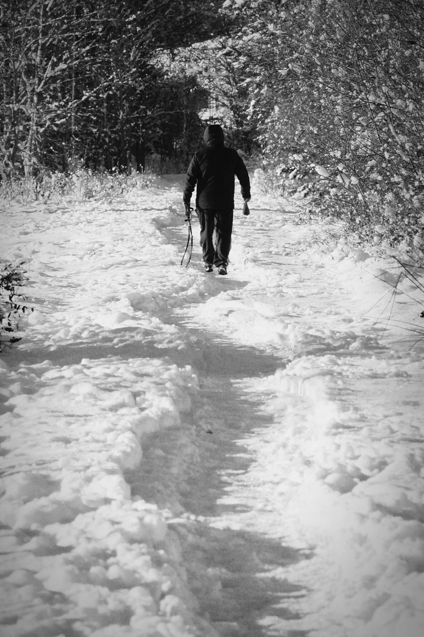 Man walking in on snow covered field