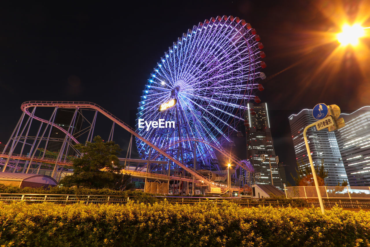 Low angle view of illuminated ferris wheel at night