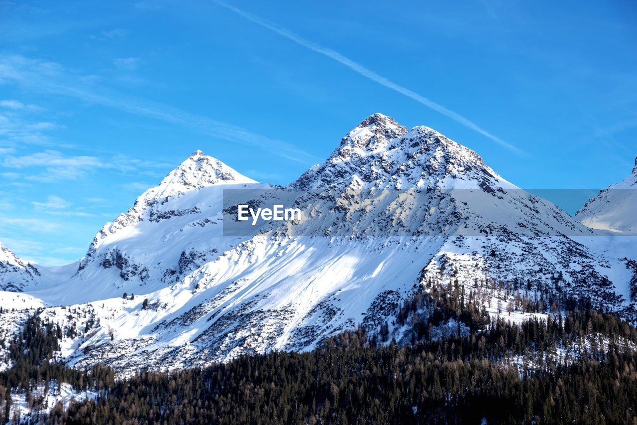 Scenic view of snowcapped mountains against blue sky