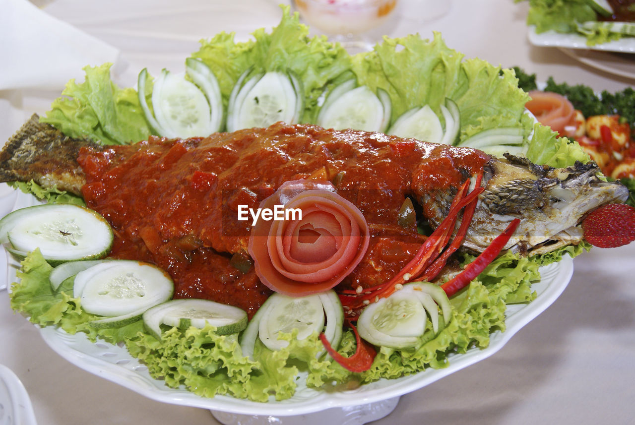 Close-up of fish garnish with sliced cucumber on table