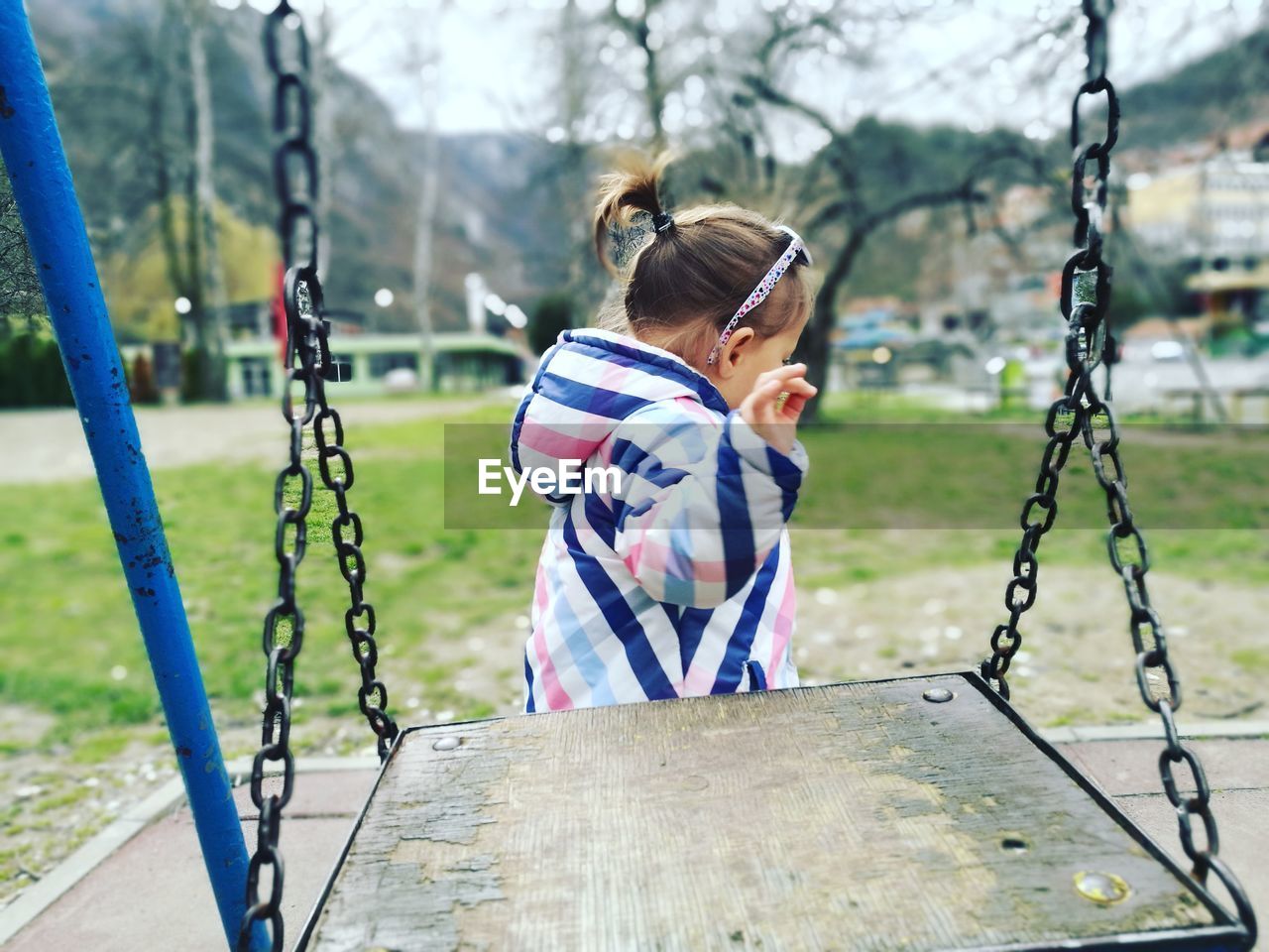 Girl walking by swing in playground