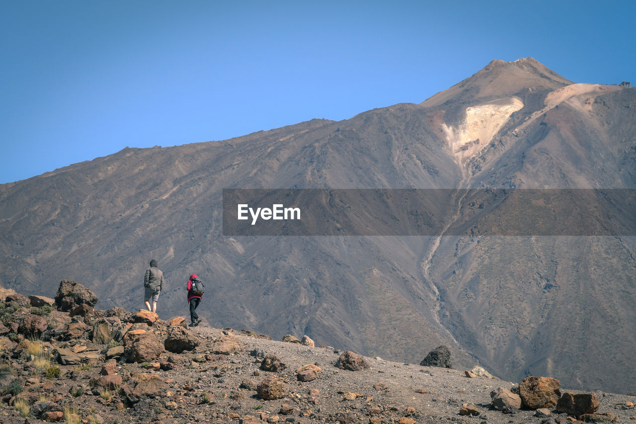 People walking against mountain