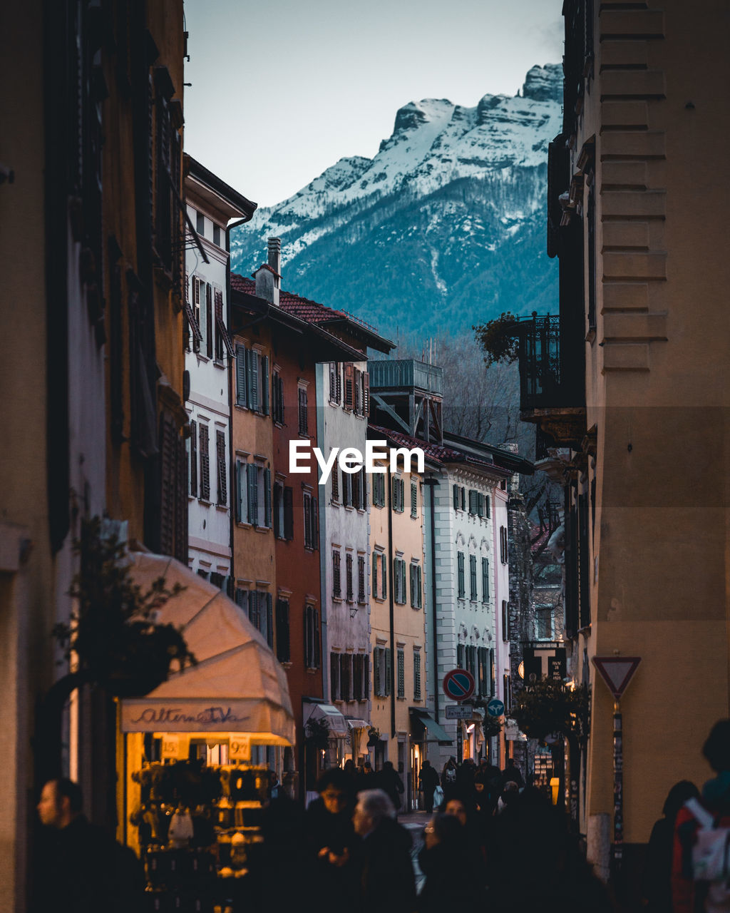 PEOPLE ON STREET AMIDST BUILDINGS AGAINST SKY