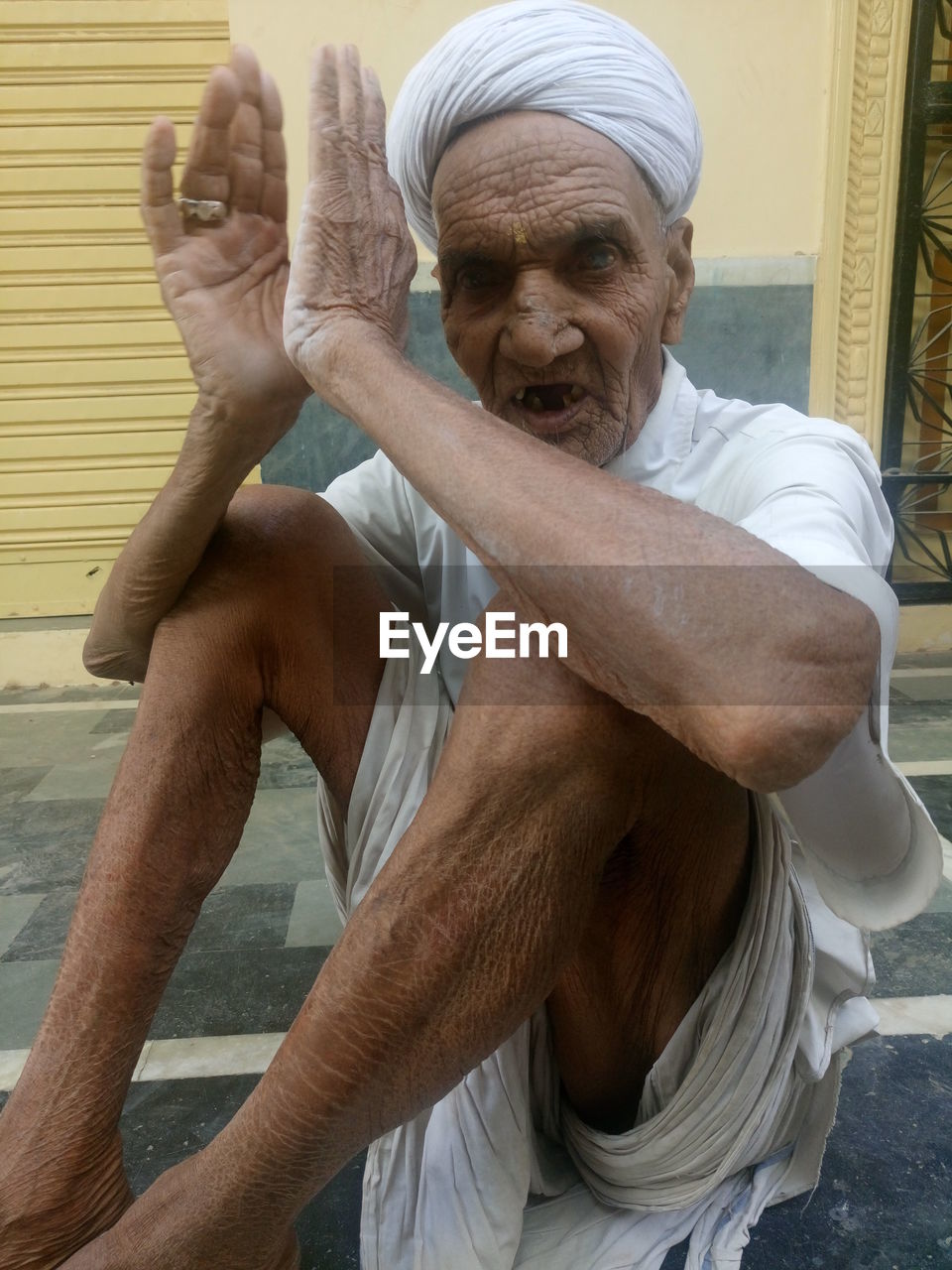 Portrait of senior man sitting outside house