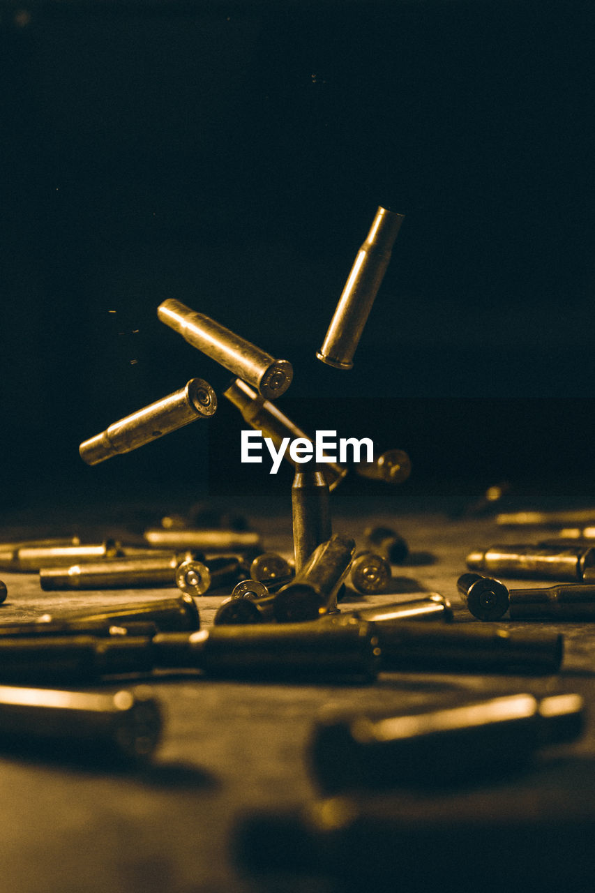 Close-up of bullet shells on table against black background