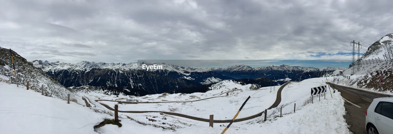 Panoramic view of snowcapped mountains against cloudy sky