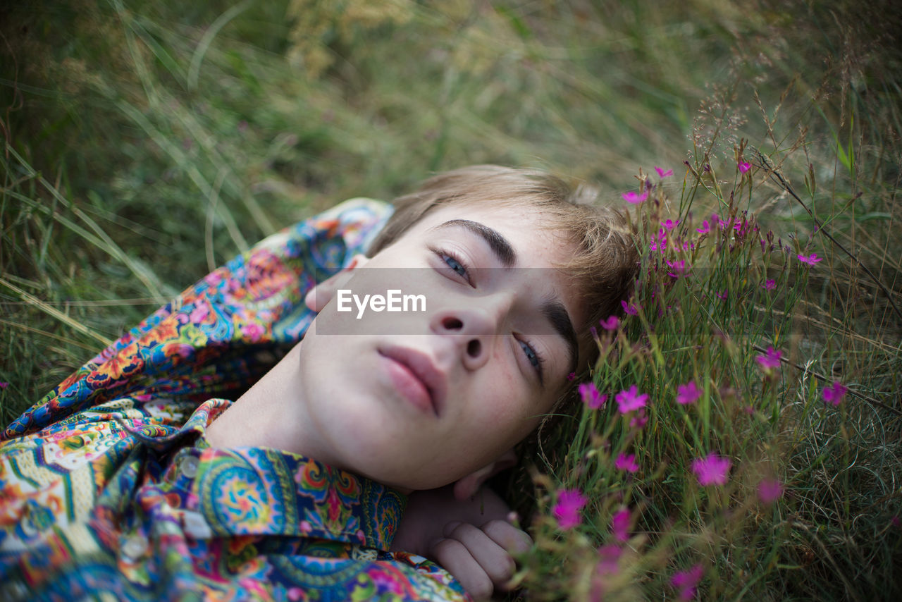 Portrait of man lying on grass