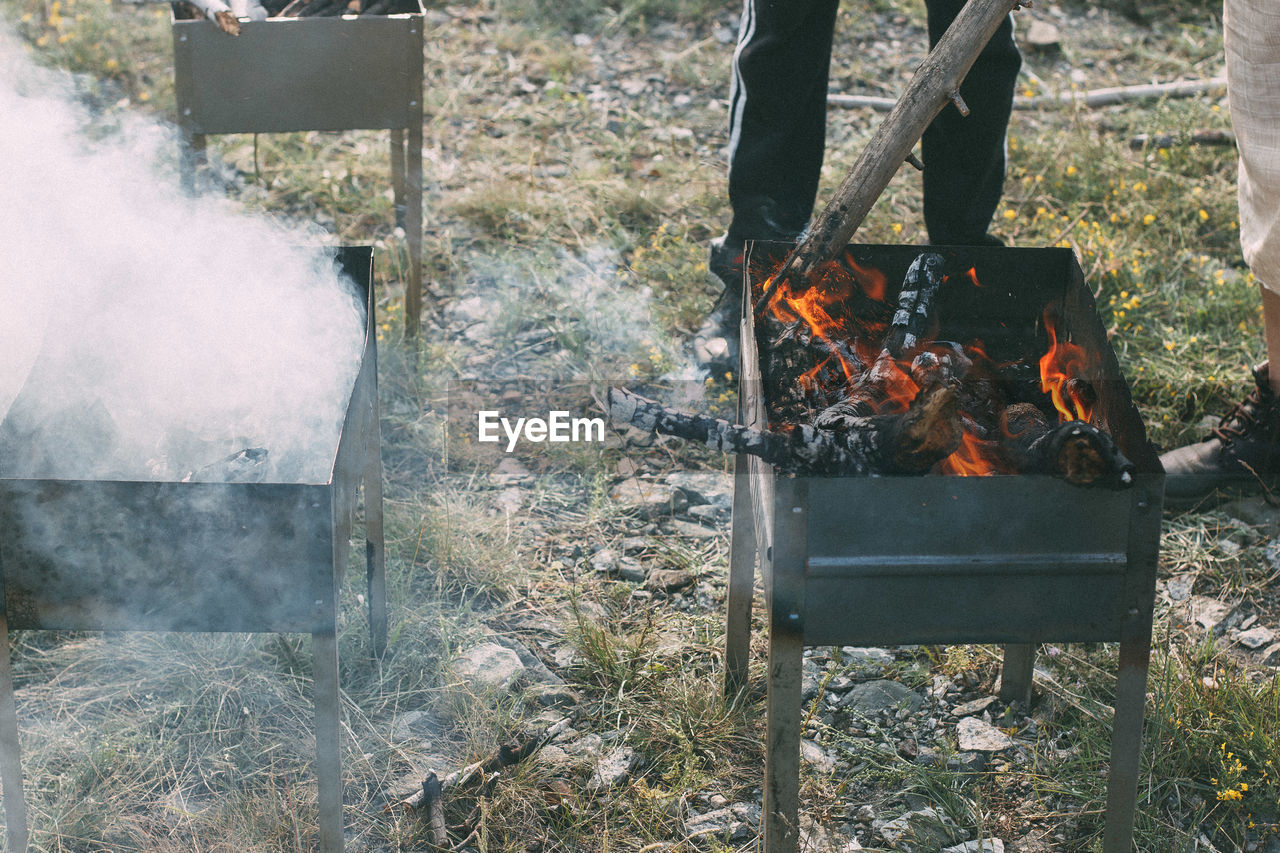 Low section of people standing by fire pit