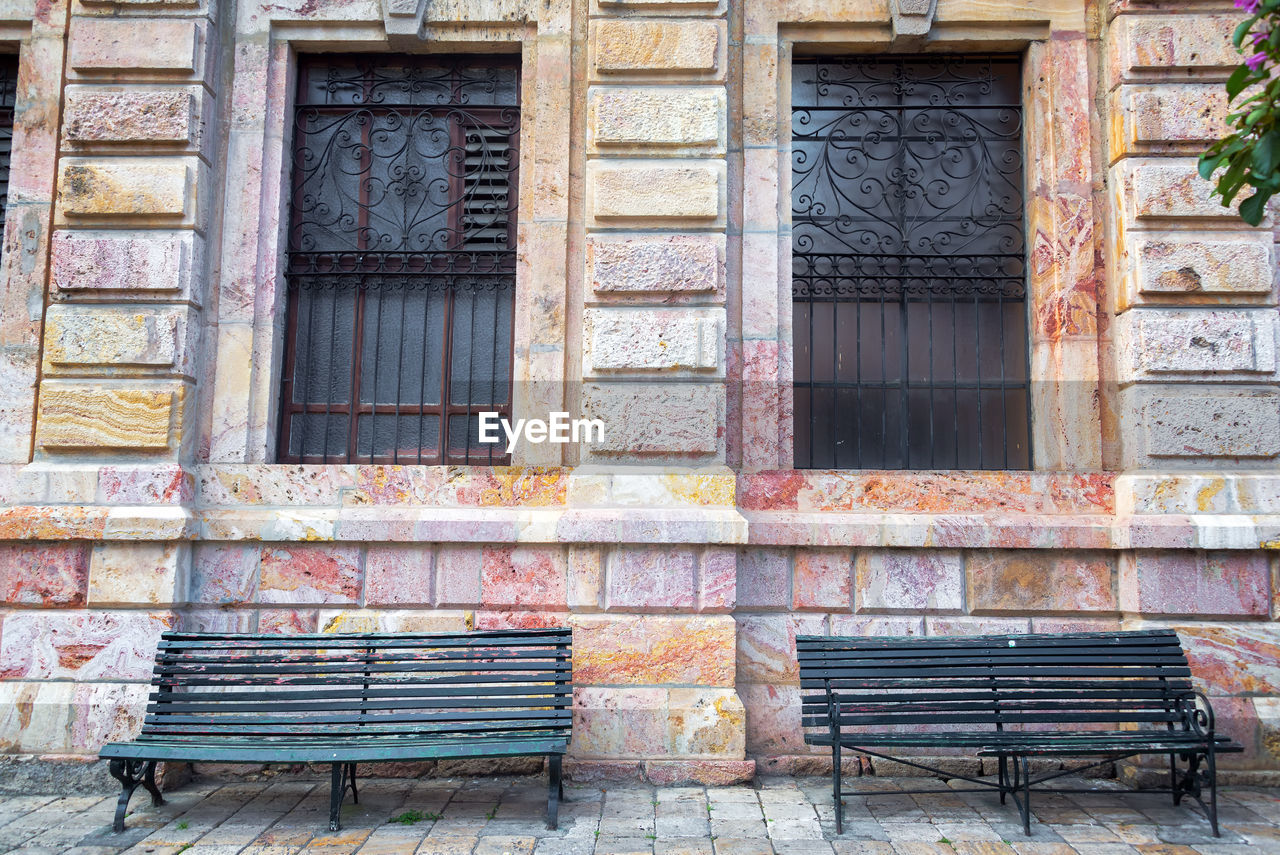 Empty benches against windows of building in san cristobal de las casas