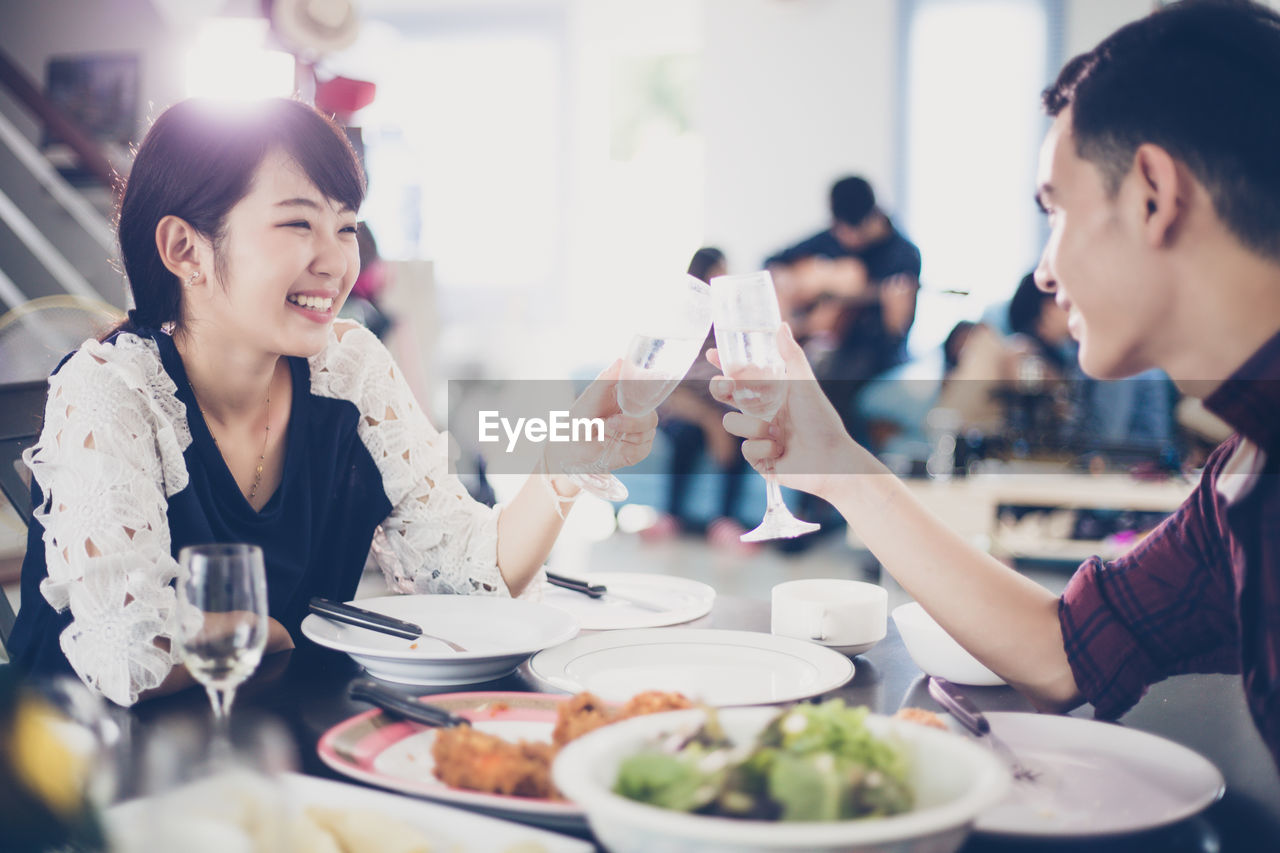 Smiling friends toasting wineglasses in restaurant