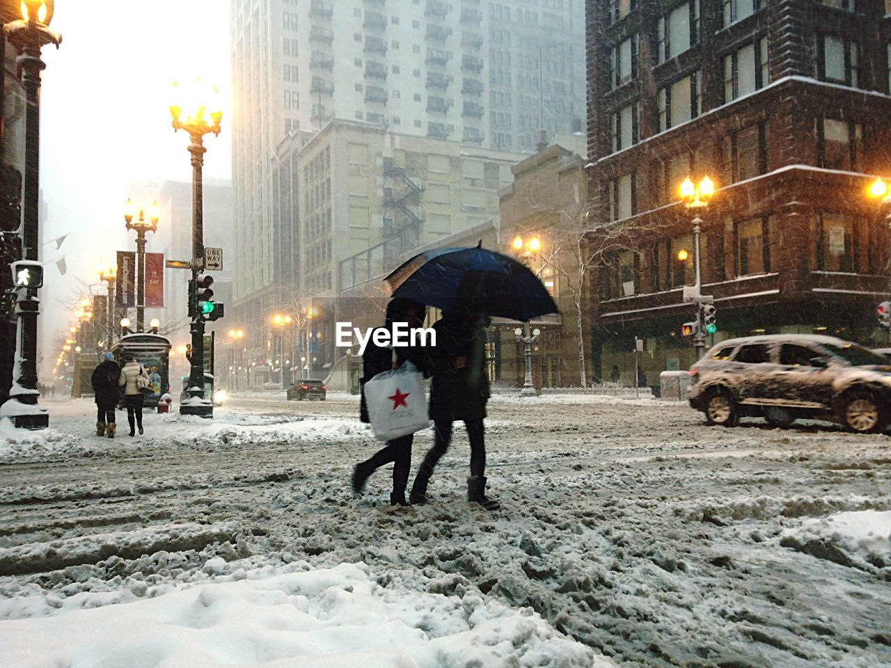 People crossing snow covered city street