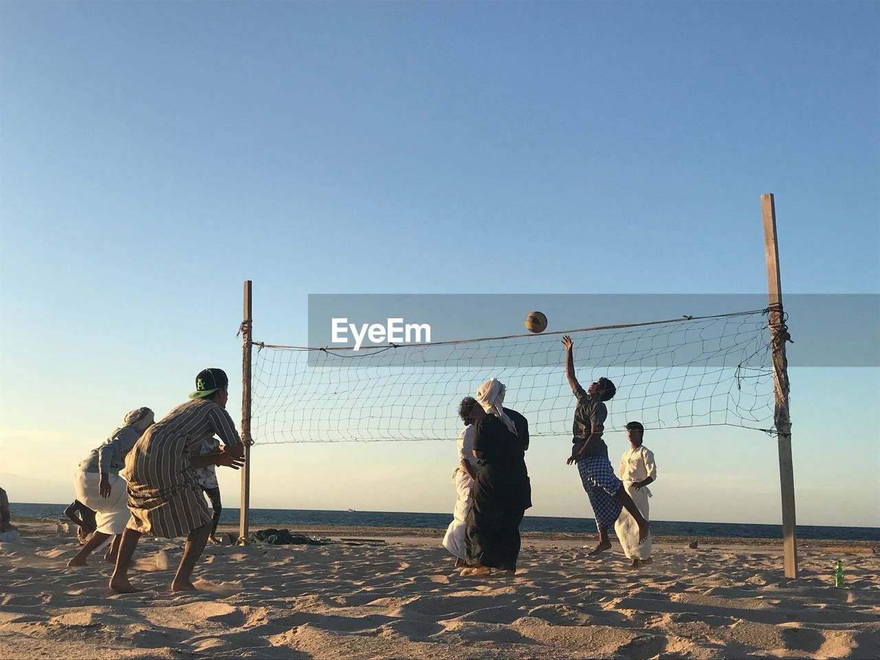 MEN PLAYING ON BEACH