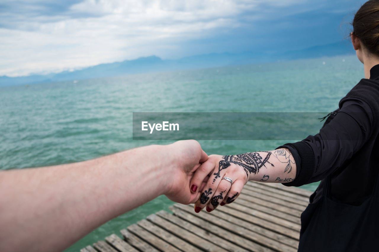 Cropped image of man holding woman hand with henna tattoo at peschiera del garda