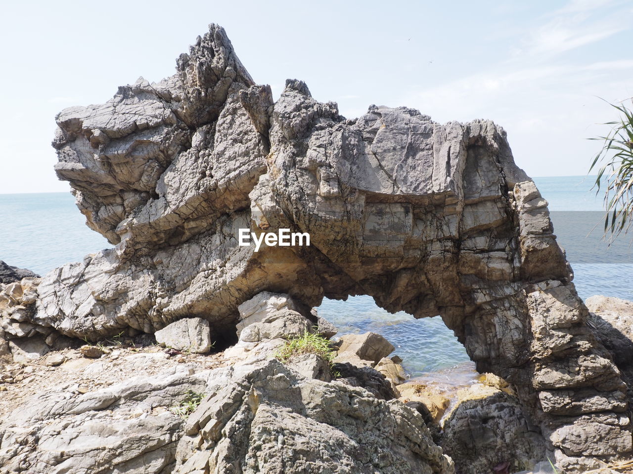 Rock formation on beach against sky