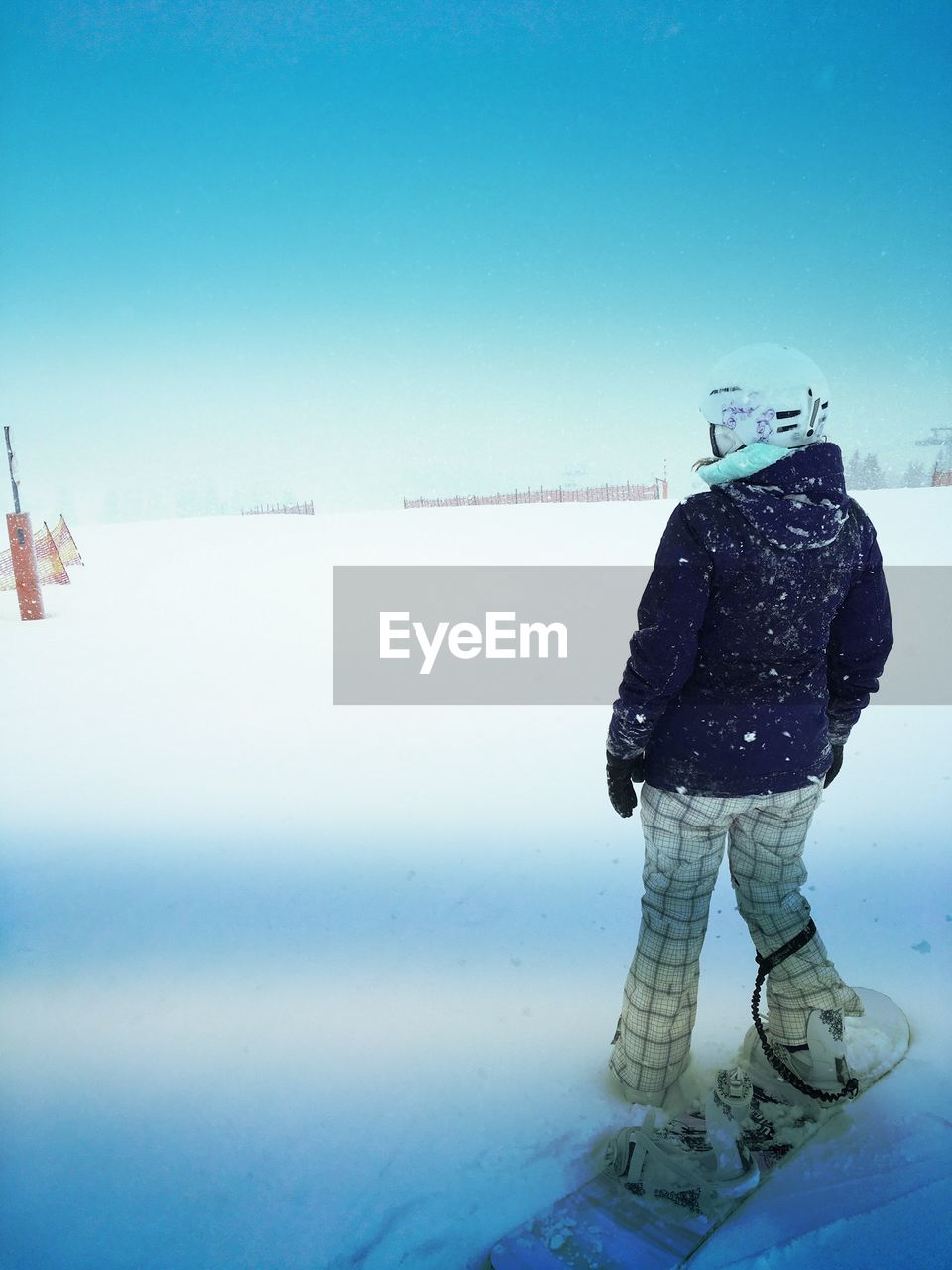 WOMAN STANDING ON SNOW AGAINST SKY