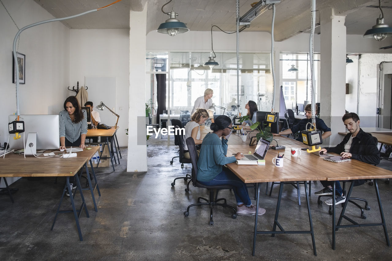 Multi-ethnic business people working at desks in office