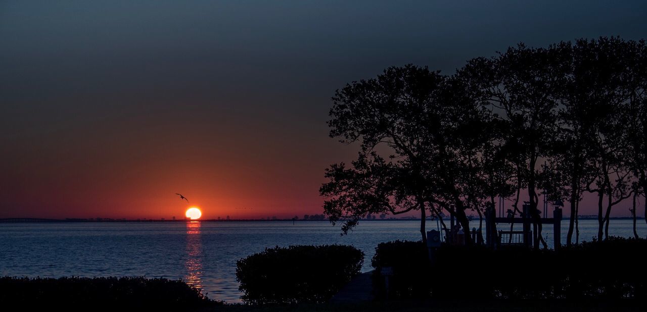 Scenic view of sea against clear sky at sunset