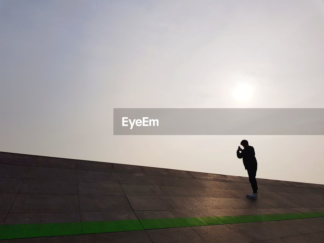 Man standing on built structure against clear sky