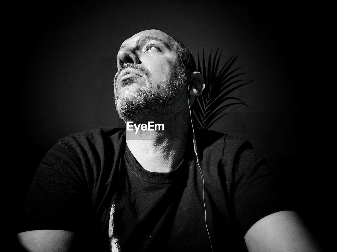 Portrait of young man looking away over black background