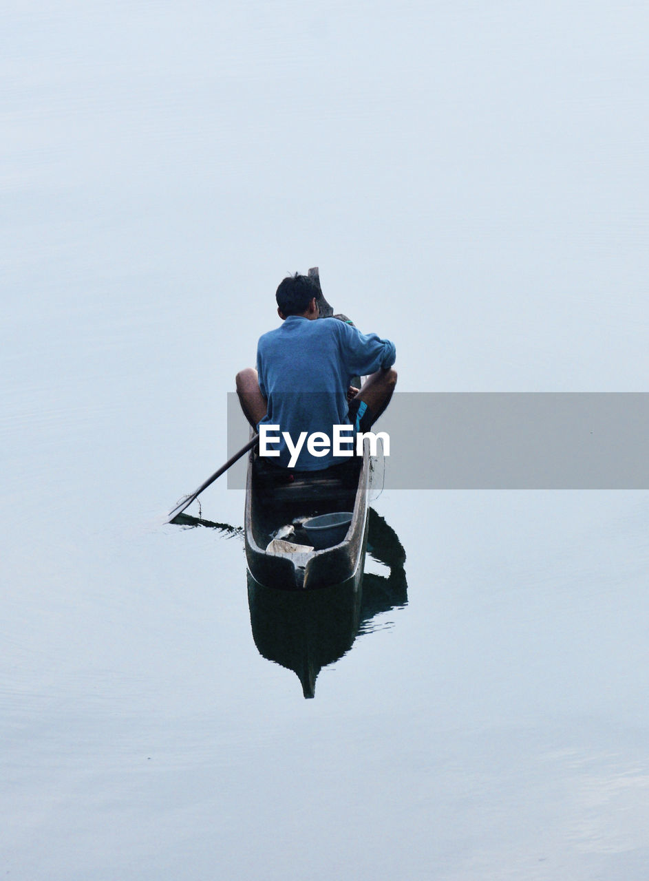 Man sitting in boat on sea