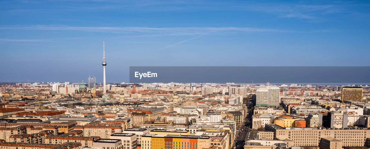 Scenic view of residential district against blue sky