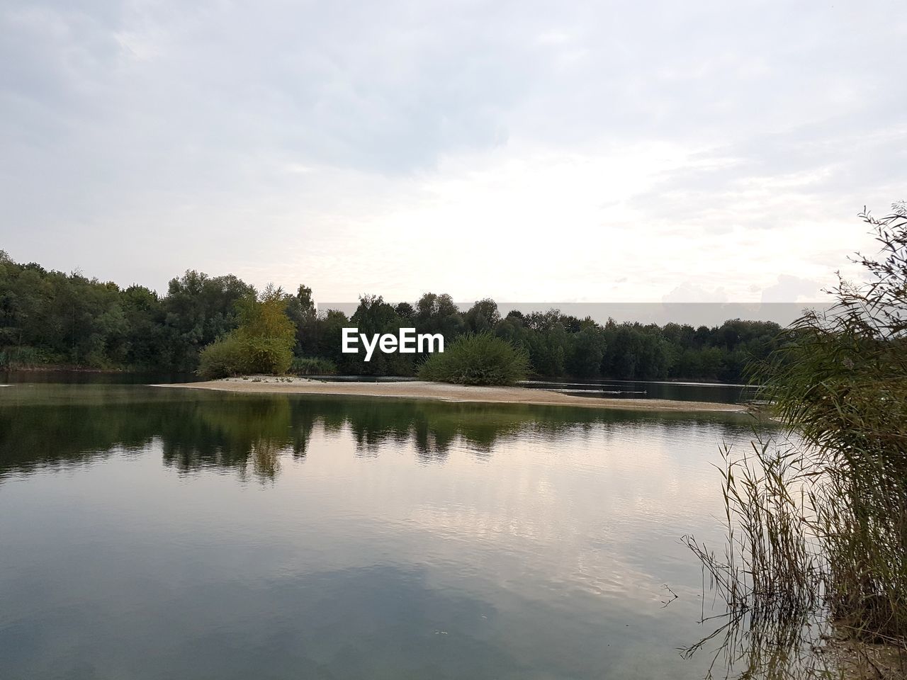 REFLECTION OF TREES ON LAKE AGAINST SKY