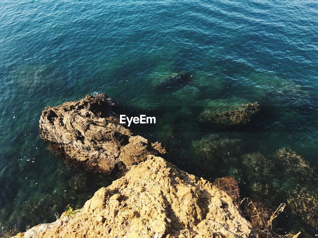 HIGH ANGLE VIEW OF SEA AND ROCK FORMATION IN WATER