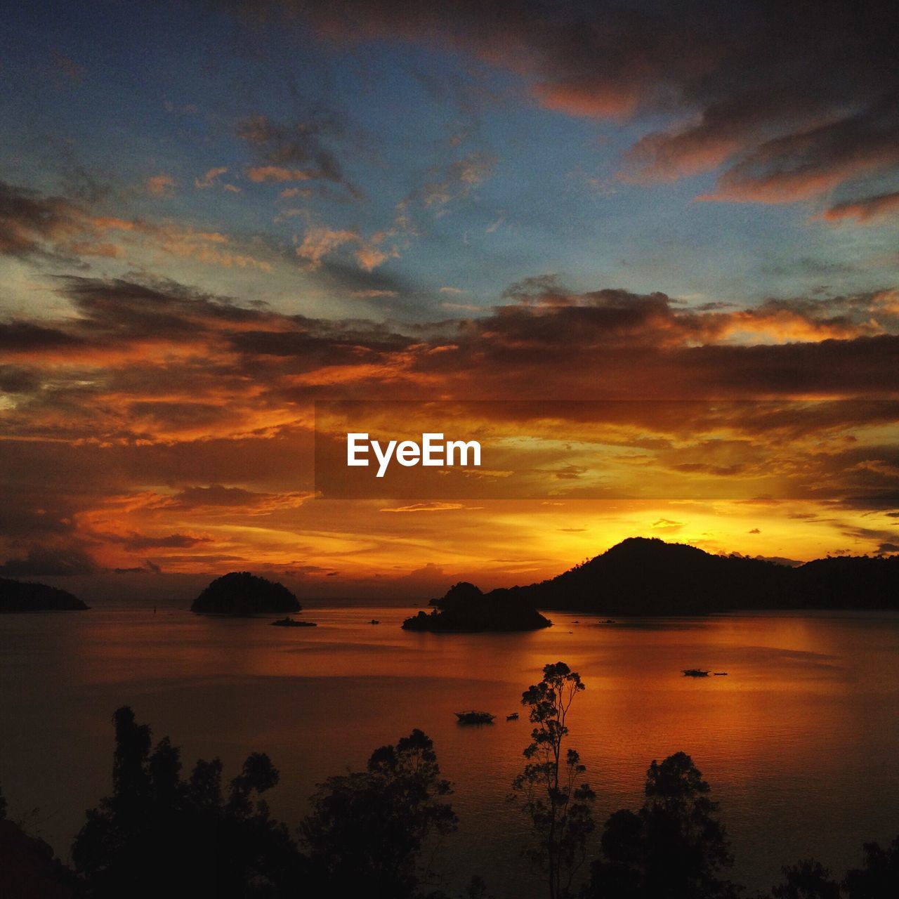 Scenic view of sea against dramatic sky during sunset