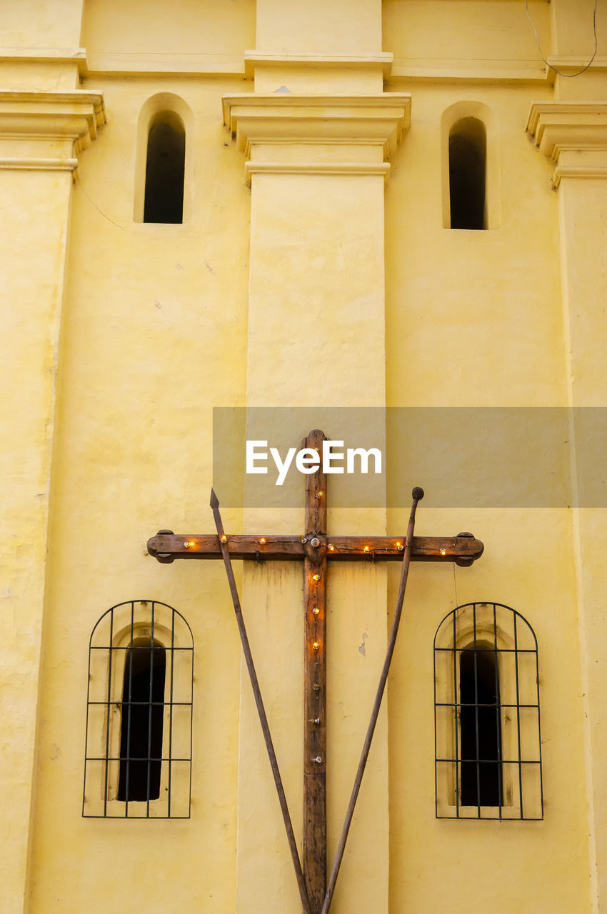 Wooden cross mounted on church wall