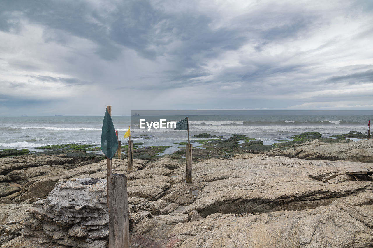 sea, shore, beach, sky, coast, water, land, ocean, cloud, wave, nature, rock, body of water, scenics - nature, beauty in nature, cliff, horizon over water, environment, bay, horizon, terrain, sand, tranquility, coastline, wind wave, tower, vacation, outdoors, landscape, tranquil scene, holiday, day, travel destinations, travel, trip, motion, seascape, overcast, wind, architecture, no people