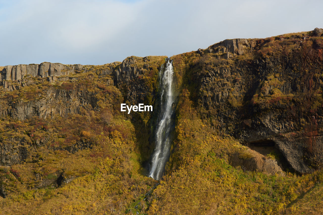 SCENIC VIEW OF WATERFALL AGAINST CLEAR SKY